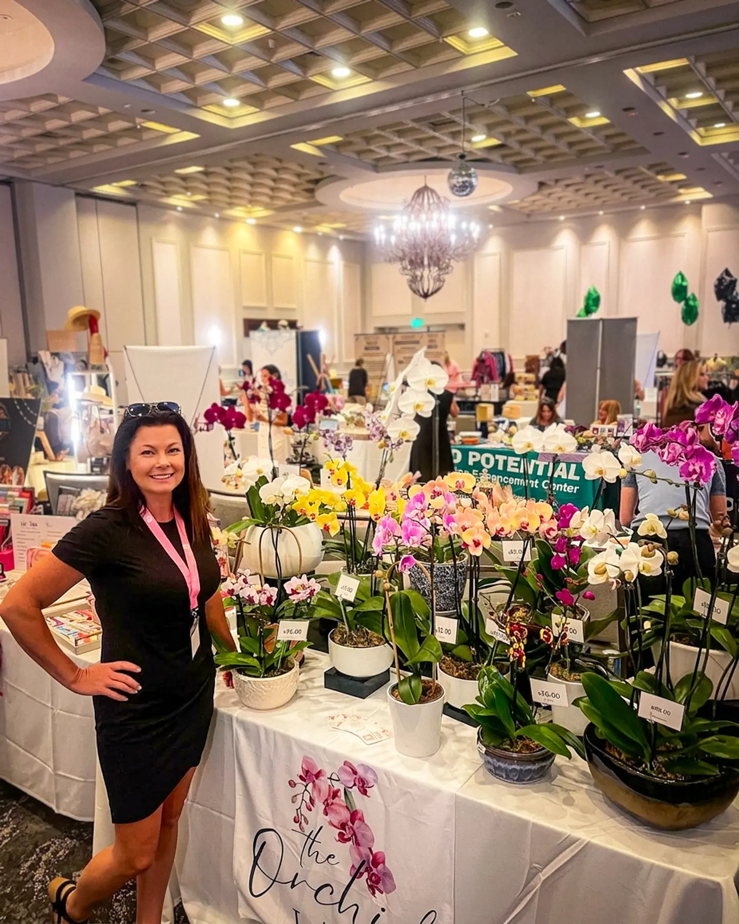Alicia Winegar arranging orchids at a trade show.